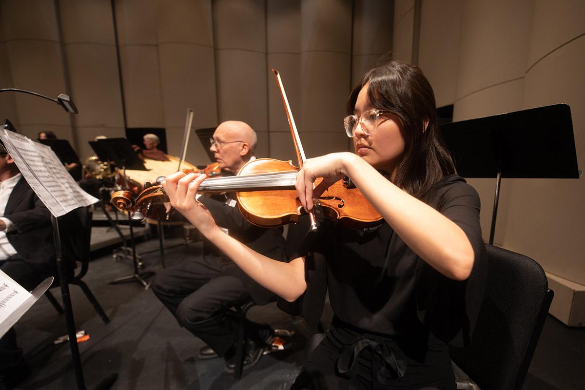 在排练期间，火博体育交响乐团演奏小提琴部分.