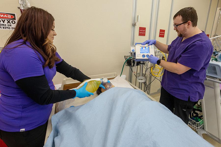 两名RT学生在医院病床上的假人上演示技能