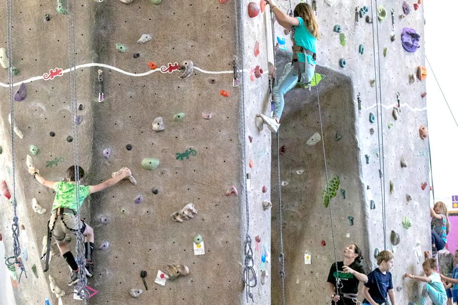 两个孩子在攀爬健康与人类表现中心的室内岩壁